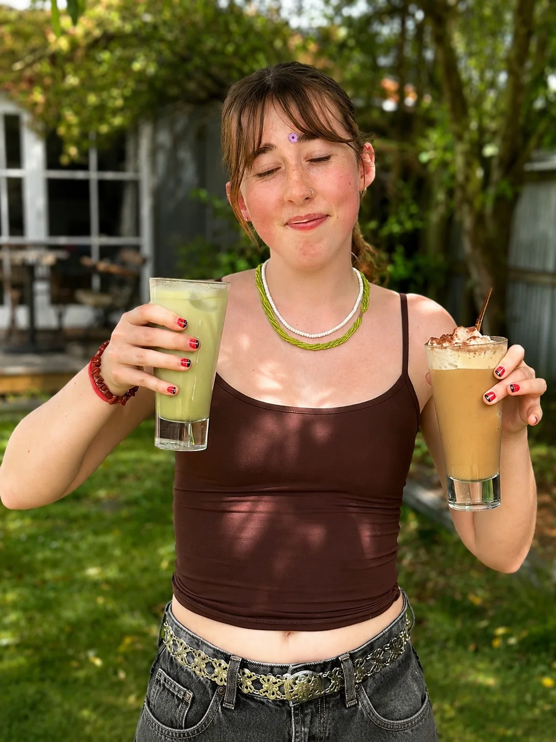 A guest holding two drinks outdoors at Portershed